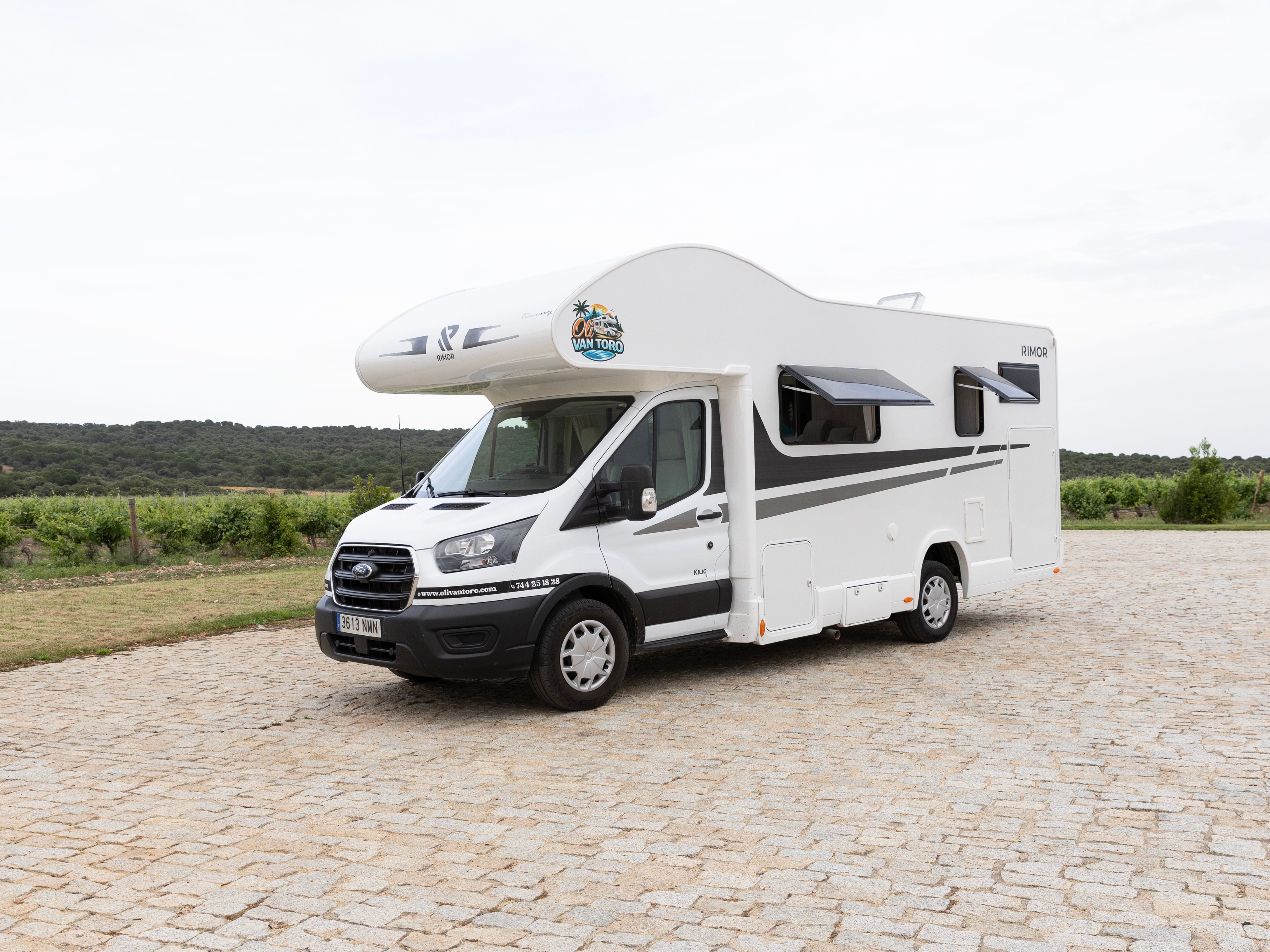 Autocaravana en un prado verde con montañas